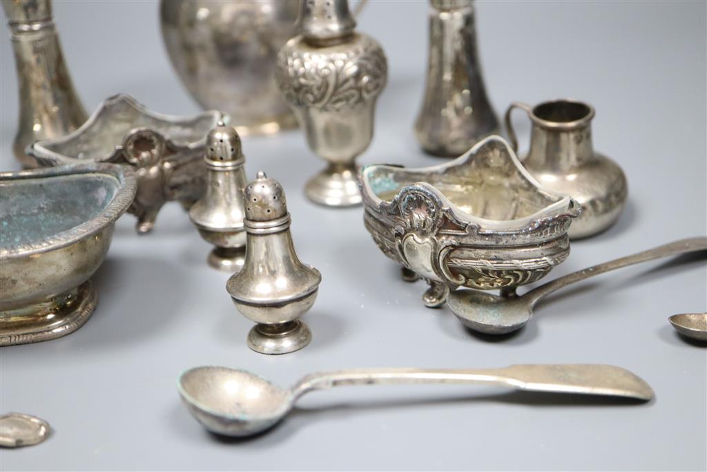 A George V silver cream jug and a collection of small silver and plated condiments and spoons.